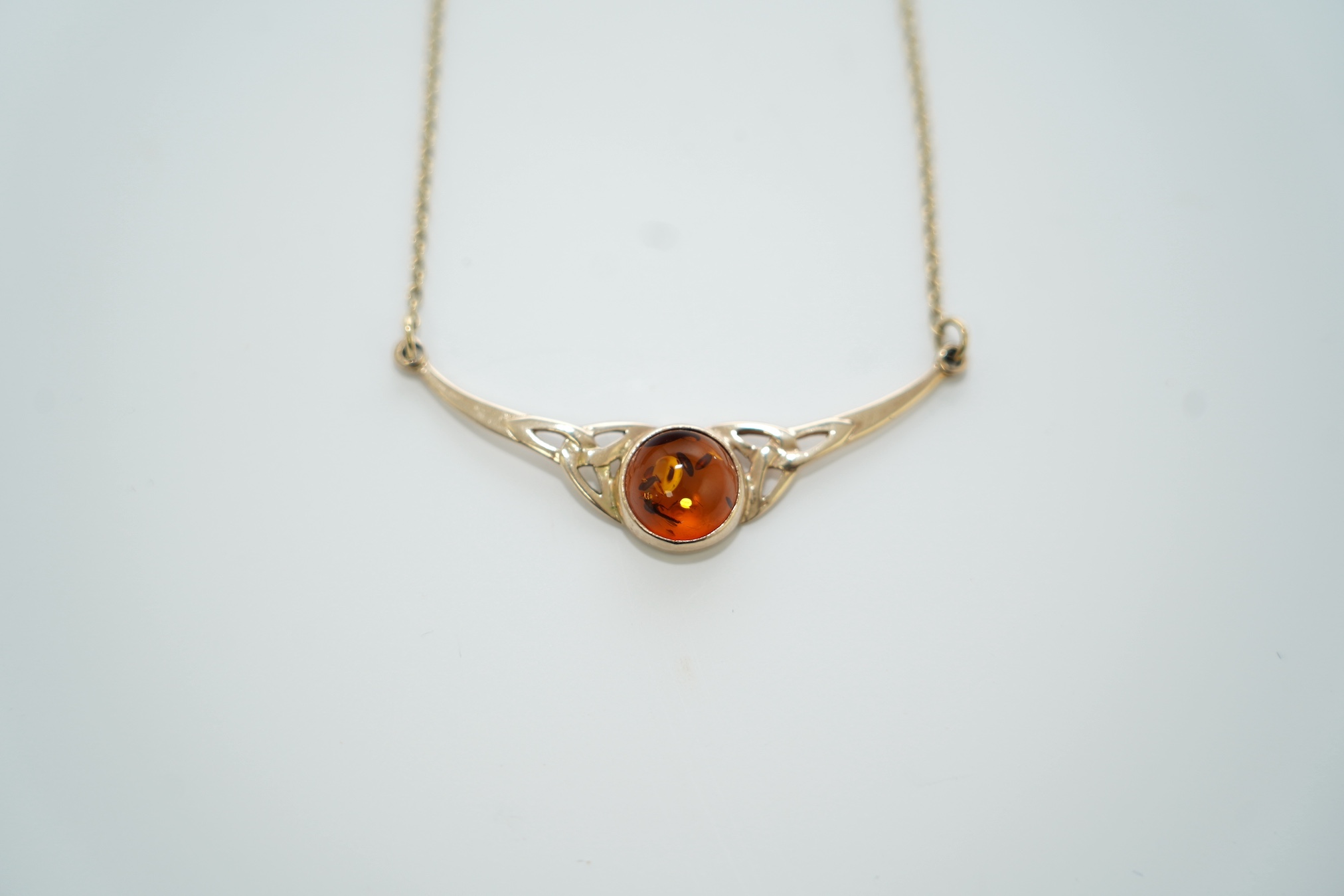 A modern suite of 9ct gold and amber set jewellery, comprising a necklace, 38cm, brooch and pair of drop earrings, gross weight 11.2 grams. Condition - good